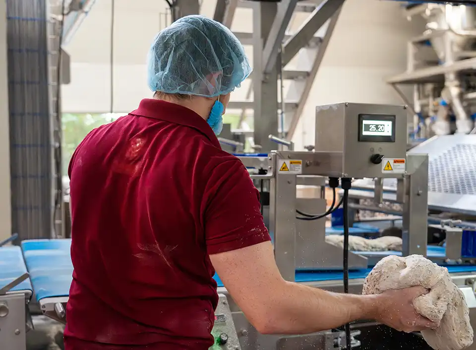 bakker bij deegmachine